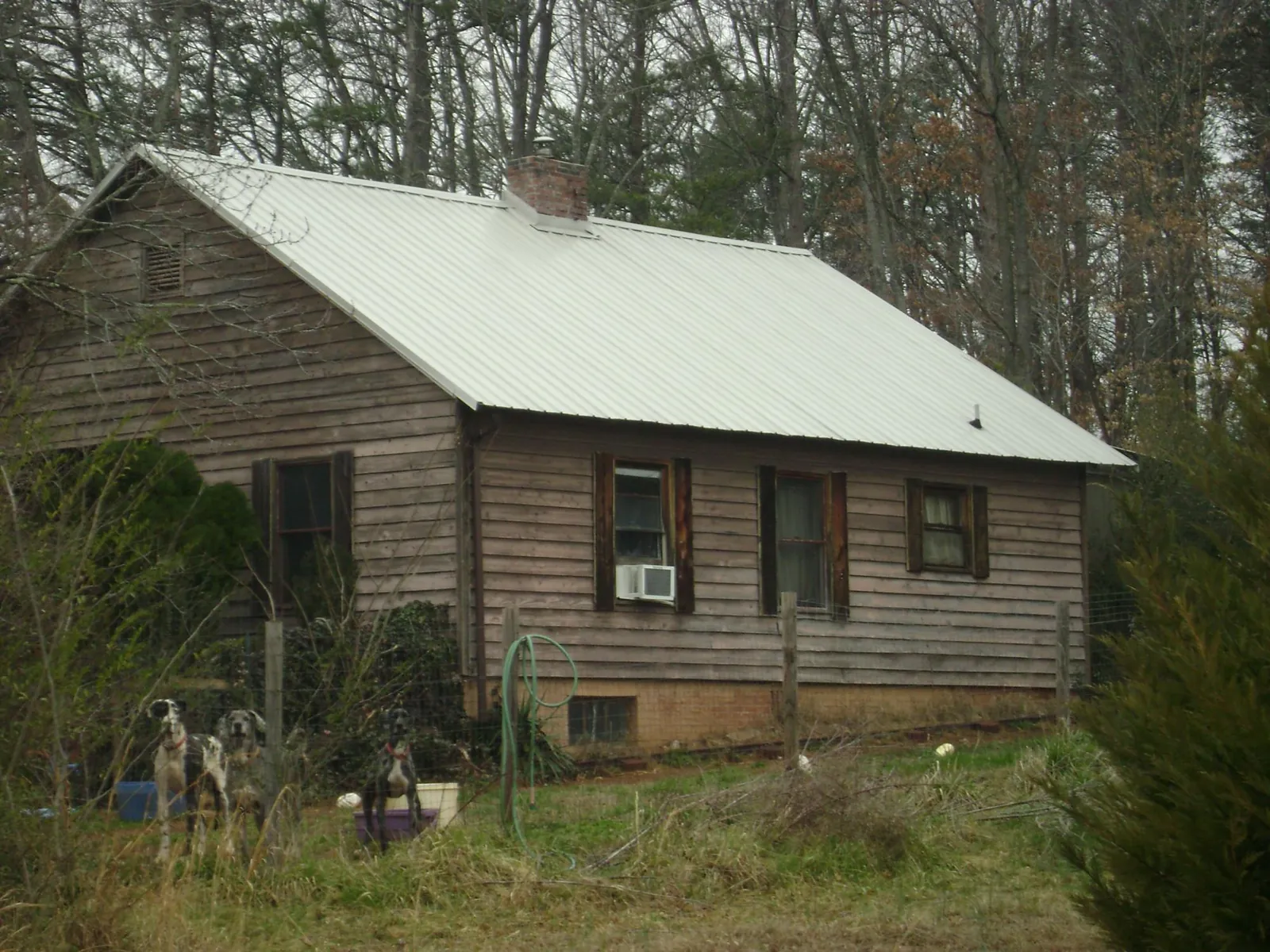 White metal roof on an old wood sided farmhouse, from a Metal Roof Installation job in Gray